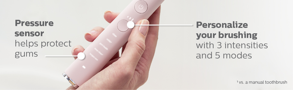 pembe diş fırçası sapının alt kısmını tutan kişi