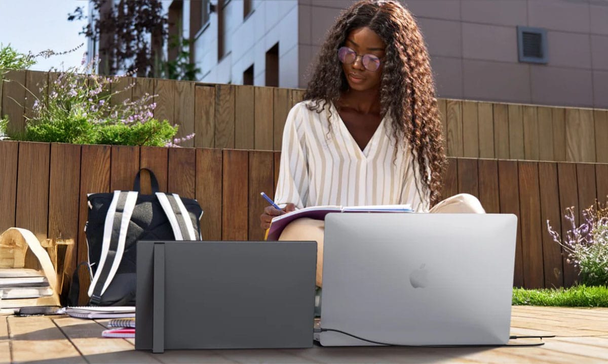 Yüksek çözünürlüklü MacBook ve dizüstü bilgisayar ile dış mekanda çalışan genç kadın, açık hava çalışma alanında modern teknoloji ve mobil ofis çözümleriyle verimlilik sağlıyor.