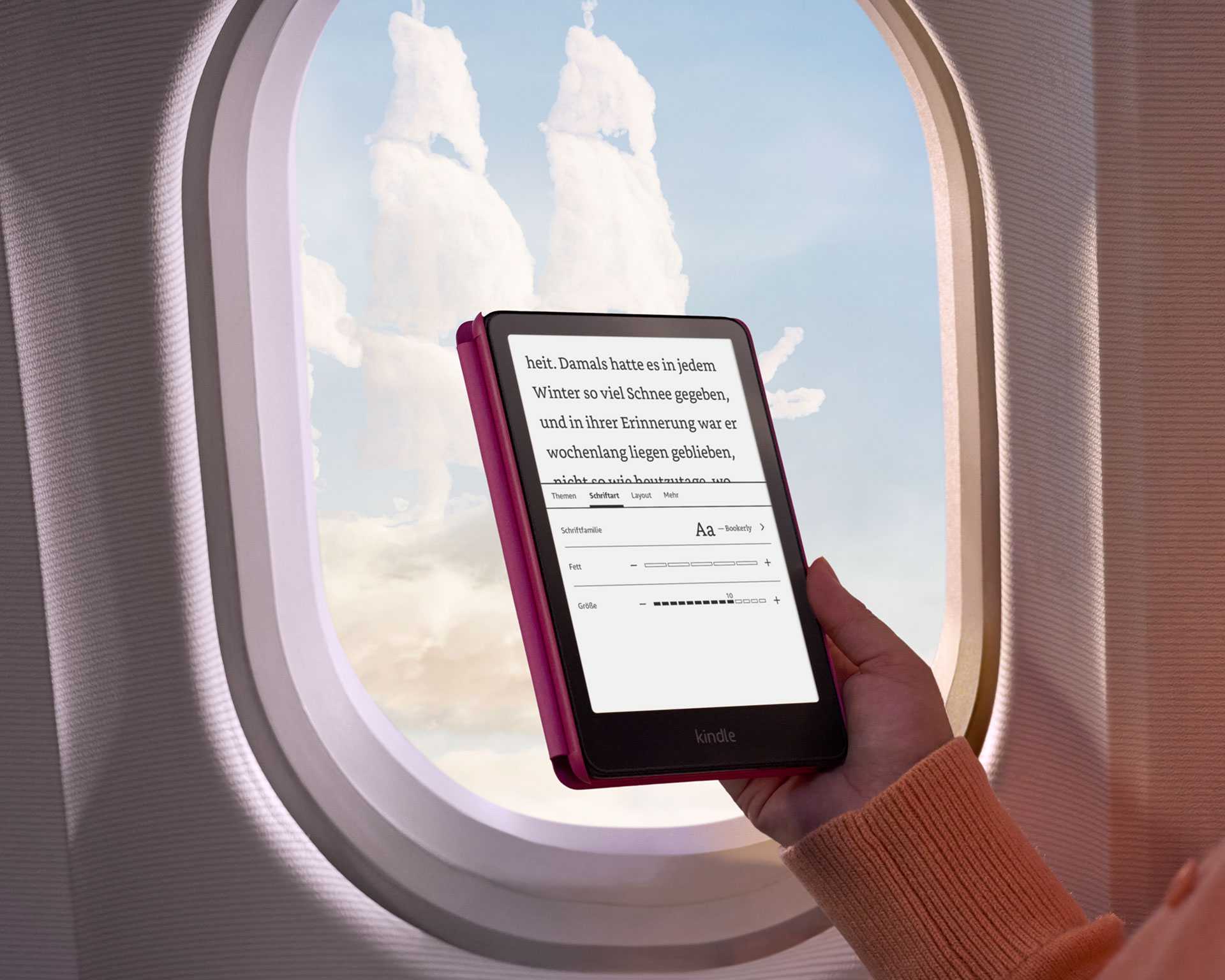 Bir okuyucu, Kindle Paperwhite'ı uçağının penceresine tutuyor. Dışarıda, korsan gemisi şeklindeki bulutlar görülebiliyor.