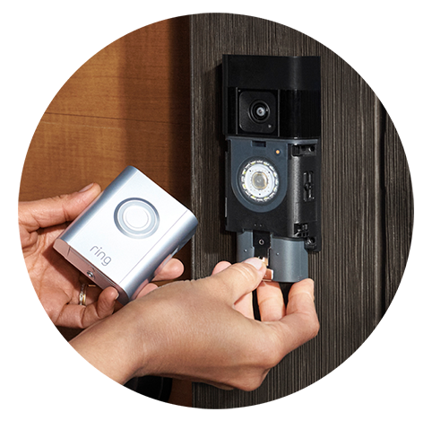 Bir kişi, ahşap bir duvara monte edilmiş Ring Battery Video Doorbell Pro'nun pilini çıkarıyor. Sol eliyle ön paneli tutuyor ve sağ eliyle pili çıkarıyor.