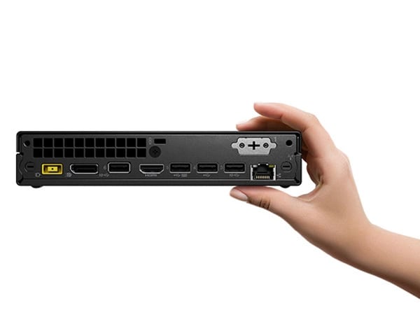 Lenovo ThinkCentre Neo 50q Gen 4 Tiny (Intel) cihazının, bir ofis masasında, monitör ve klavyenin (ayrı satılır) yanında dikey olarak durduğu, klavyede yazan bir kişinin bulunduğu yakın çekimi