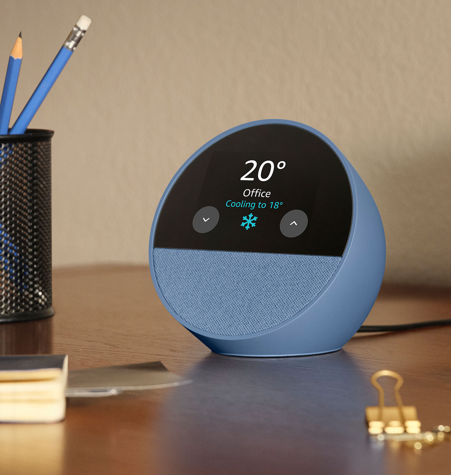 Echo Spot is on a desk. The 2.8-inch display shows the weather and the thermostat in the home office. The thermostat icon shows text 