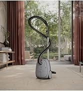 Kahverengi perdeler ve ahşap raflı pencereye doğru kavisli yaka zemin lambası ile modern ev dekorasyonu.