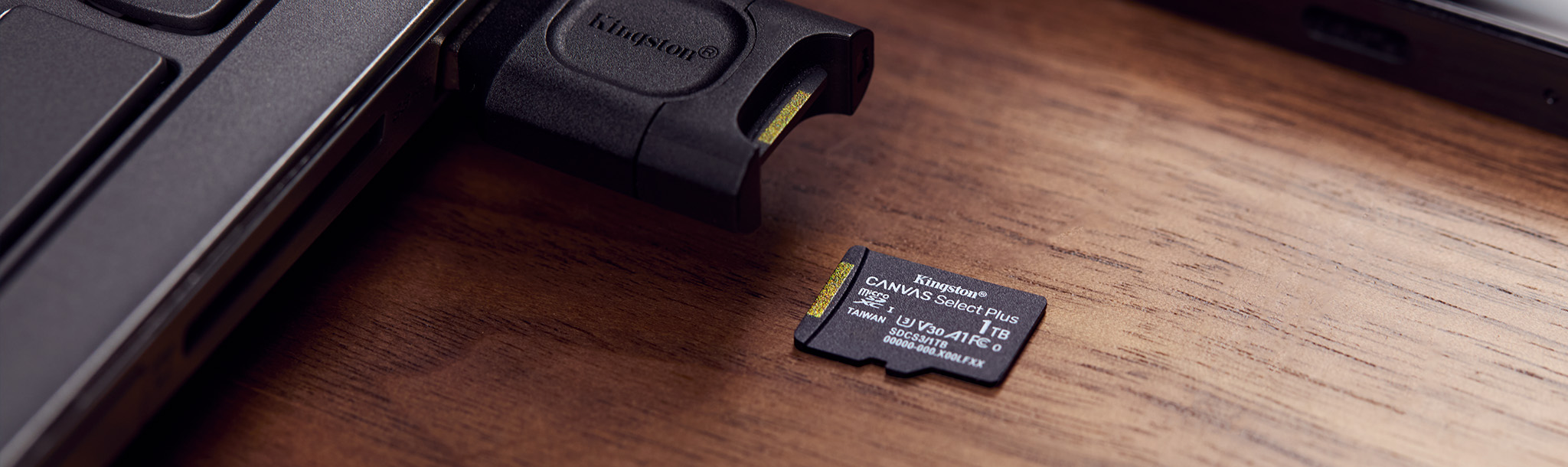 Kingston MLP SD kart okuyucunun yanındaki bir masaya yerleştirilmiş 1 TB Canvas Select Plus microSD