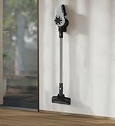 Beyaz renkli kablosuz duvar süpürgesi bej perdeler ve ev bitkisi ile modern iç mekan dekorunda sunulur