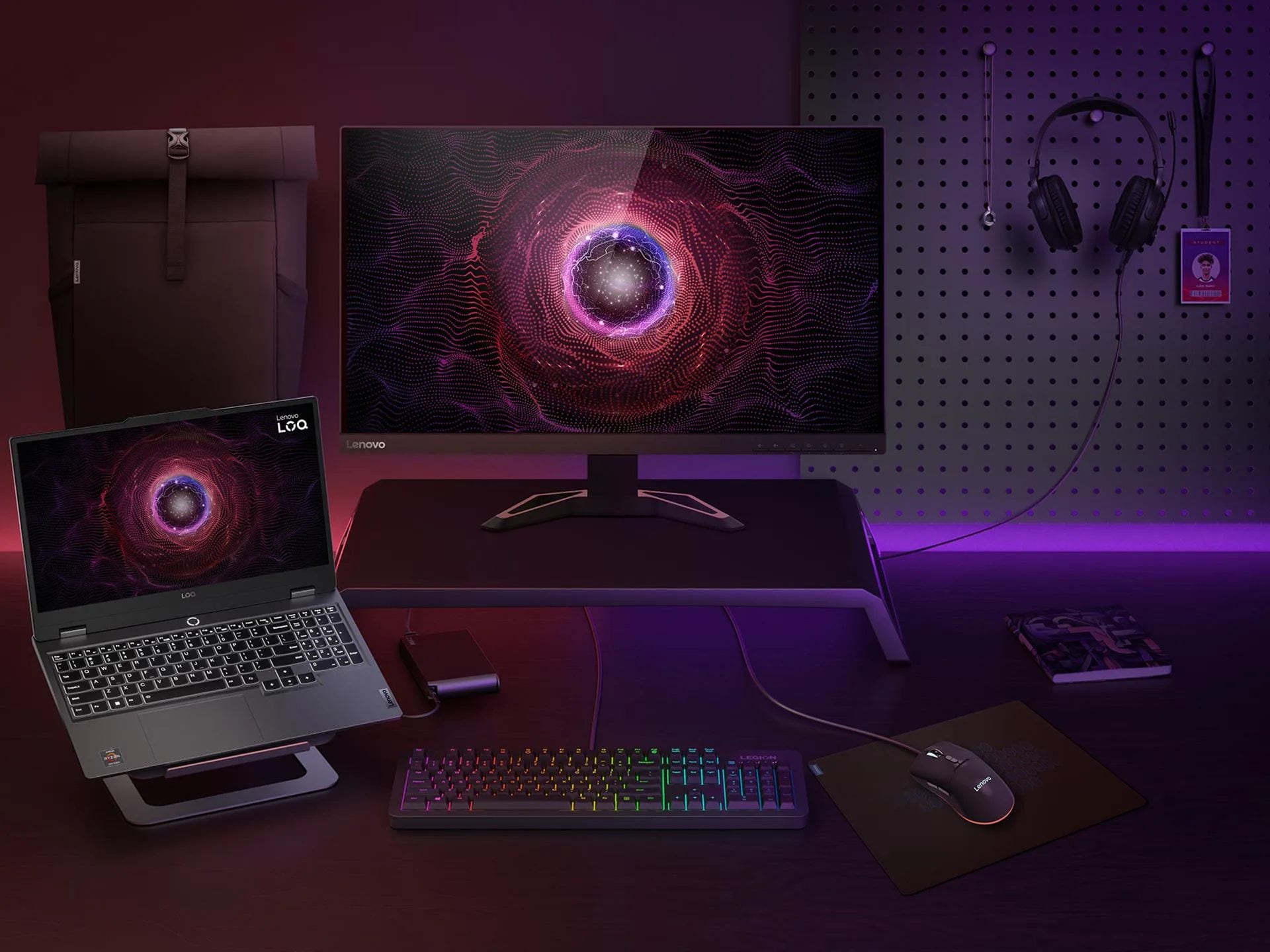 Lenovo LOQ 15ARP9, monitör, fare, klavye, kulaklık ve diğer aksesuarlarla çevrili bir stand üzerinde