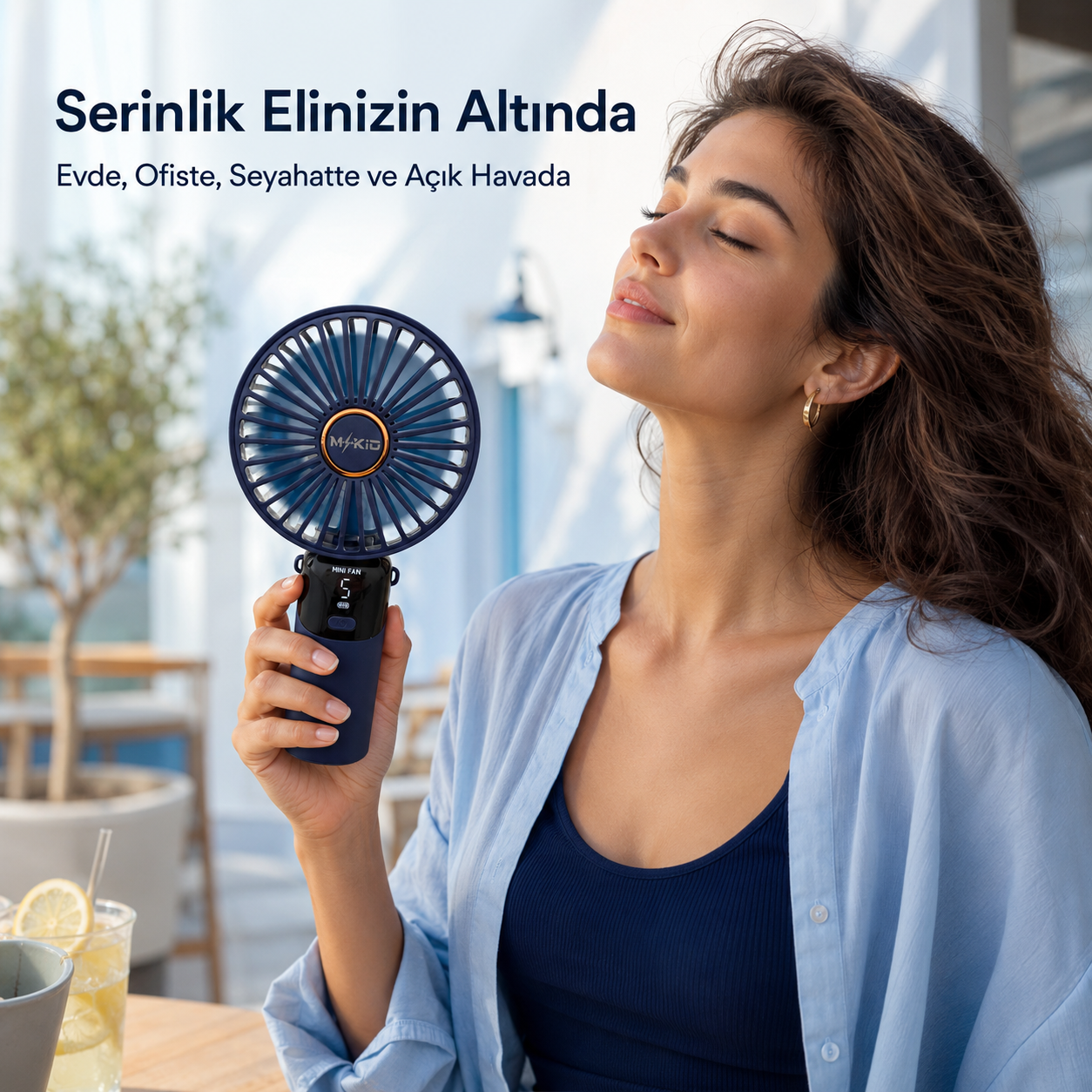 Kadının elinde MKİO lacivert taşınabilir şarjlı mini fan