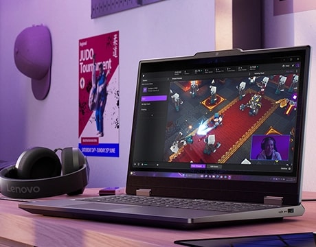 Lenovo LOQ Essential 15IRX11 oyun dizüstü bilgisayarı, kulaklıklı bir masa üzerinde - sağ önden görünüm, kapak açık, ekranda bir video oyunu ekranı var.