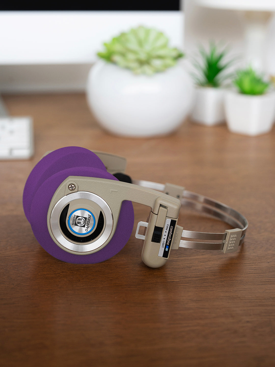 Koss Porta Pro Wireless Rhythm Beige laying on a desk with Purple Oversized Cushions