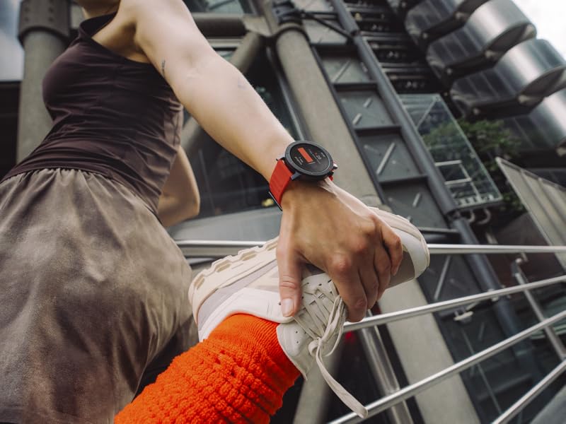 Endüstriyel tesisleri metal raylarla veya raylarla çalıştıran veya bakımını yapan ellerin yakın çekimi, akıllı saat ve turuncu koruyucu eldiven giyen bir kişiyi gösteriyor.