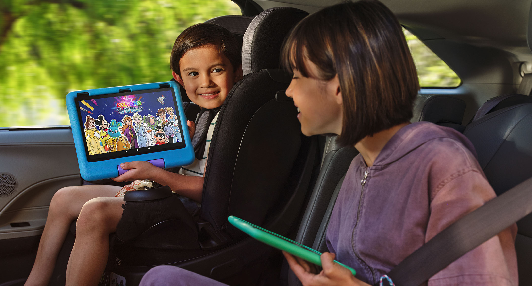 Birbirlerine destek olan büyük ve küçük kardeşler, arabanın arka koltuğunda oturup Fire HD 10 Kids tabletlerinde içerik paylaşıyorlar.
