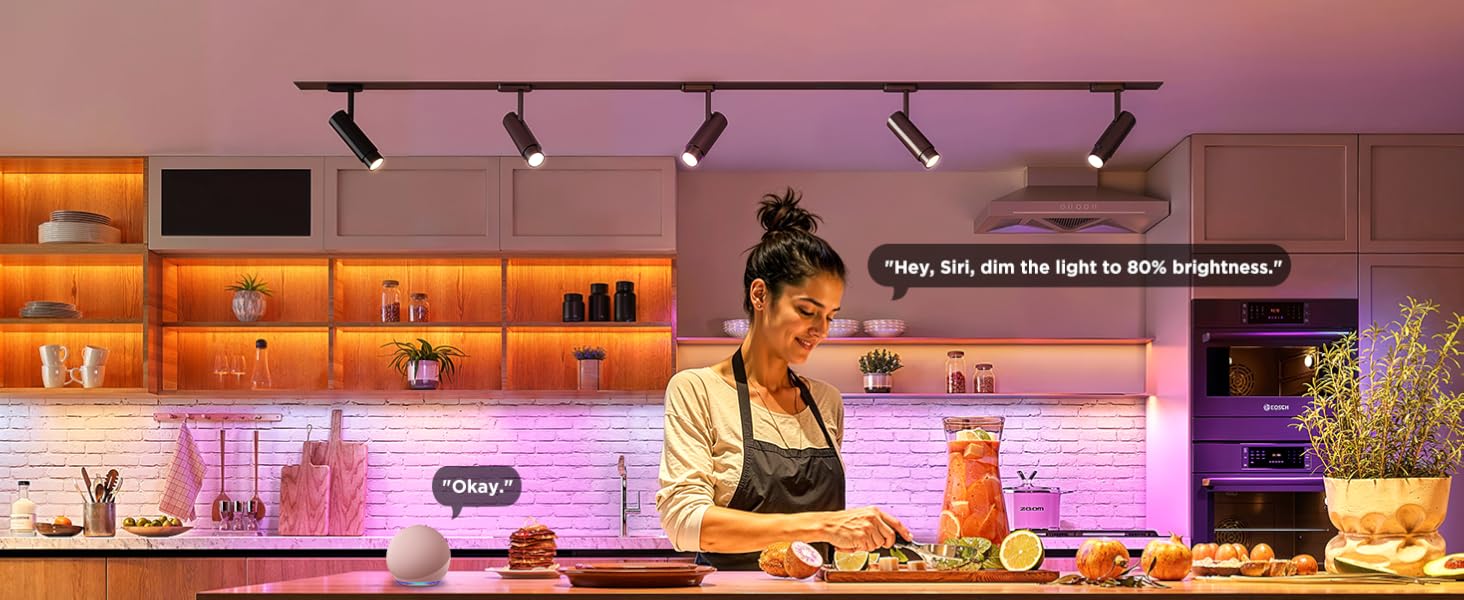 Sıcak aydınlatmalı restoran veya bar mutfak tezgahı, aydınlatılmış arka duvarda raflı şişeler ve paslanmaz çelik ekipmanlarla donatılmış yiyecek hazırlama alanı.