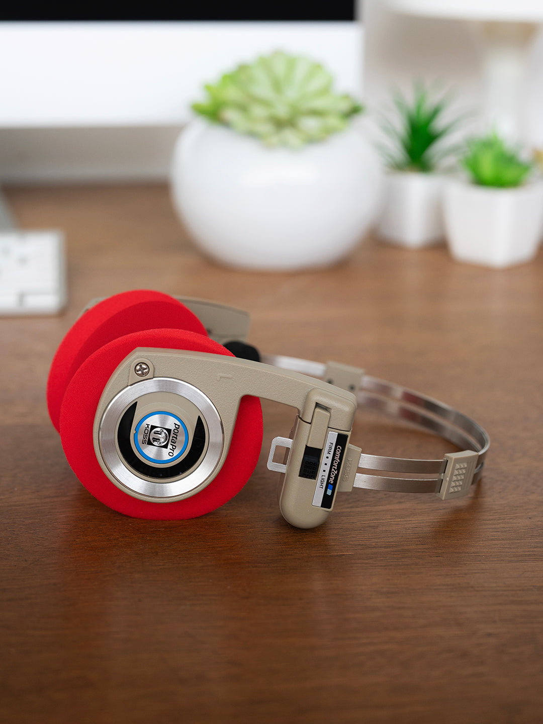 Koss Porta Pro Wireless Rhythm Beige laying on a desk with Red Oversized Cushions