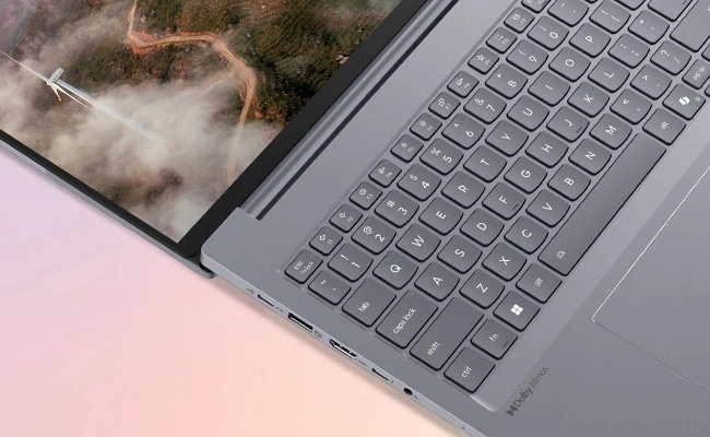 Lenovo ThinkBook 16 Gen 7 (16 inç AMD) dizüstü bilgisayarın 180 derece açılmış, ekranın sol tarafına ve görünür bağlantı noktaları ve Dolby Atmos hoparlör etiketi ile klavyeye odaklanan kısa ön sol görünümü.