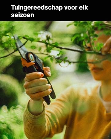 "Her mevsim için bahçe aletleri" yazıyor. Yeşil yapraklar arasında bahçe aletleri ile sarı eldivenli bir çocuk elinin yakın çekim fotoğrafı.