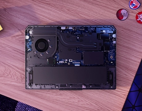 Masa üzerinde Lenovo LOQ Essential 15IRX11 oyun dizüstü bilgisayarı - alttan görünüm, dahili bileşenleri ortaya çıkarmak için kapak çıkarılmış.
