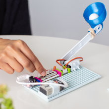 Bir fırlatma kolu STEM buluşuna bağlanan bir devre modülünün elle kontrol edilmesi.