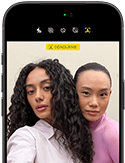 iPhone 18 Pro, siyah, önden dış görünüm, ekranında kameraya poz veren iki model var, Center Stage ön kamera gösteriliyor